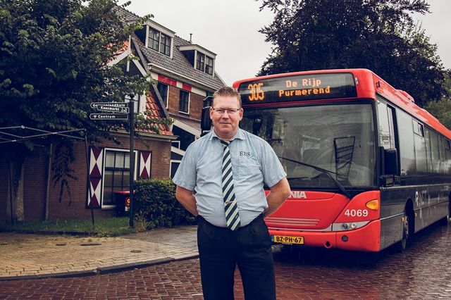 Buschauffeur voor zijn bus in Laag Holland.