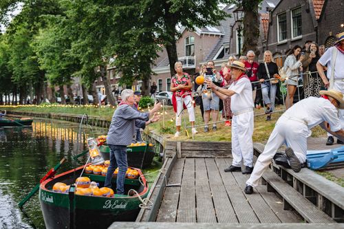 Mannen die kazen overgooien tijdens de avondkaasmarkt in Edam