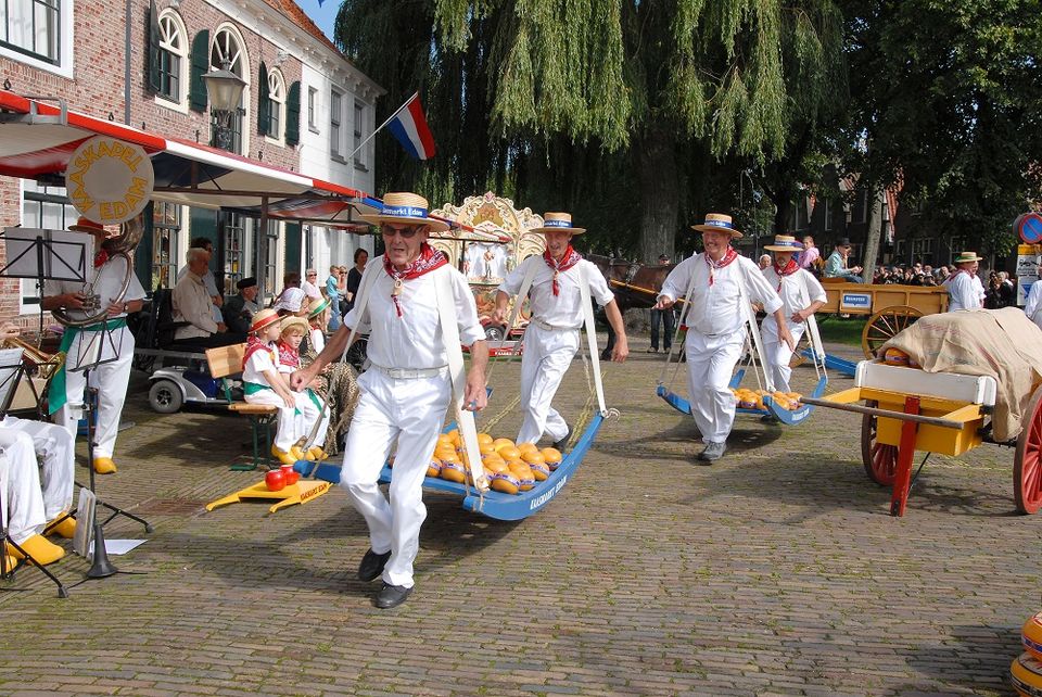Mannen die kaas aan het dragen zijn op de Kaasmarkt in Edam