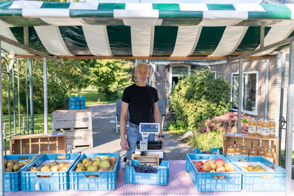 Een man achter zijn fruitkraampje
