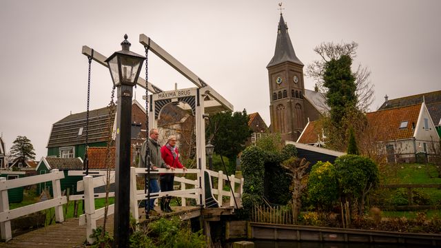 Twee mensen die op een brug stil staan in Marken