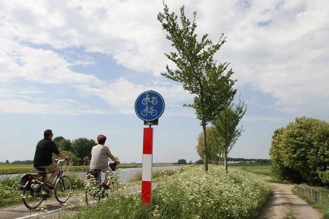 Twee fietsers die fietsen op de Zuiddijk in de Beemster