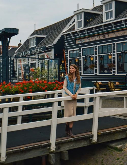Een vrouw die op een brug in Marken staat
