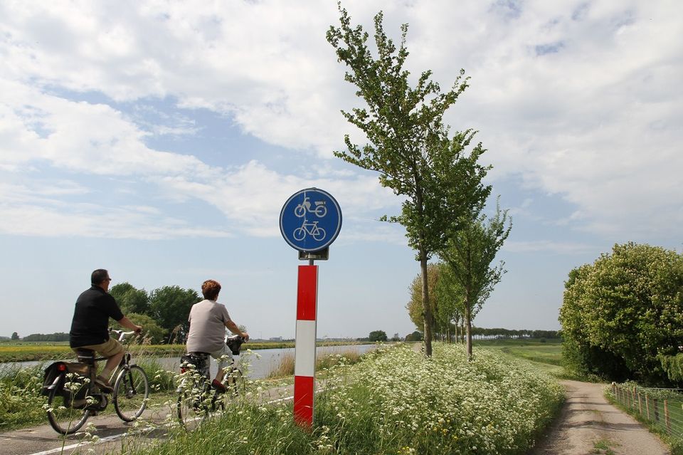 Twee fietsers die fietsen op de Zuiddijk in de Beemster