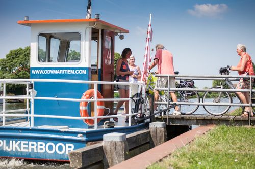 Groep mensen die met de fiets het pontje bij Spijkerboor op stappen.