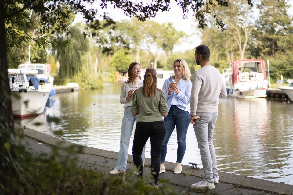 Een groepje mensen staat te kletsen aan de waterkant in Purmerend.