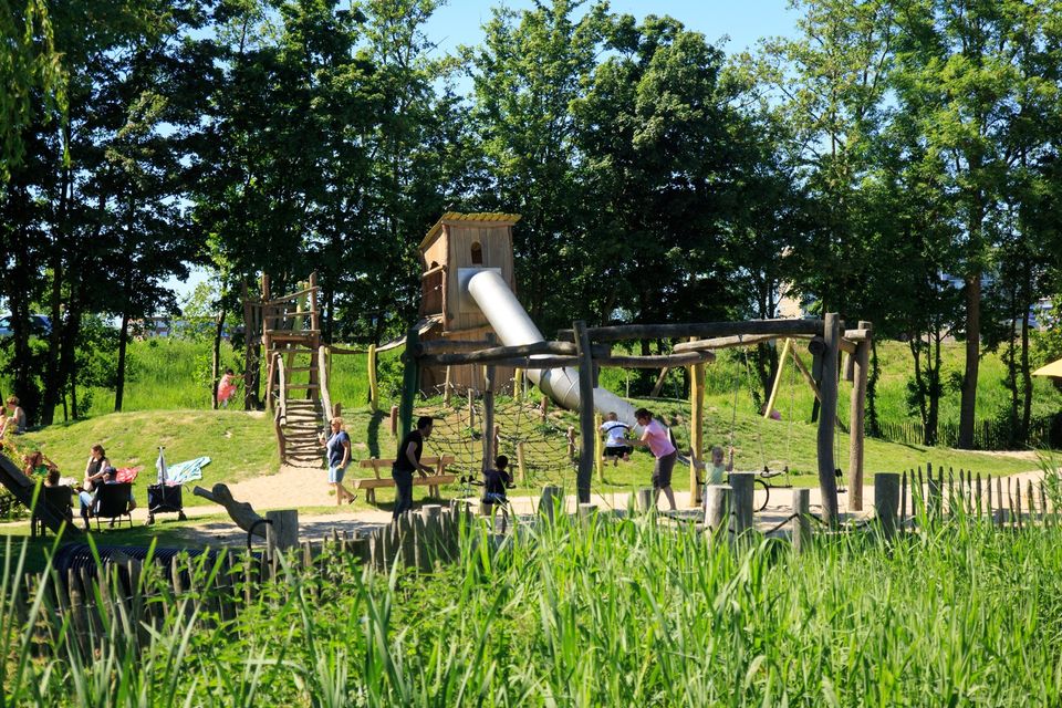 Een houten speeltoestel met hoge glijbaan in speeltuin De Speelkraam in Purmerend.