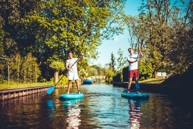 Twee jongens die op een supboard staan in Laag Holland.