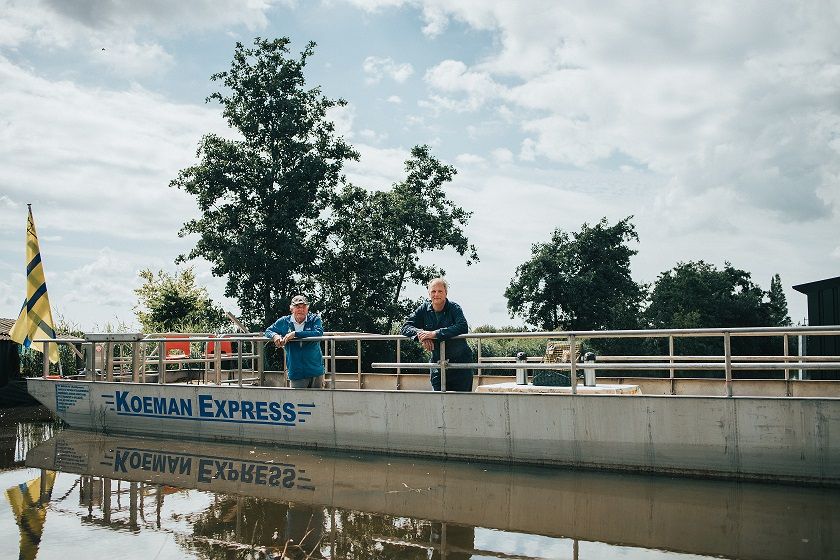 Martin (vaarboer Oostzanerveld) en Jan (gids) in het Oostzanerveld op de Koeman Express. Dit is een echte platbodem dat is omgebouwd tot rondvaartboot.