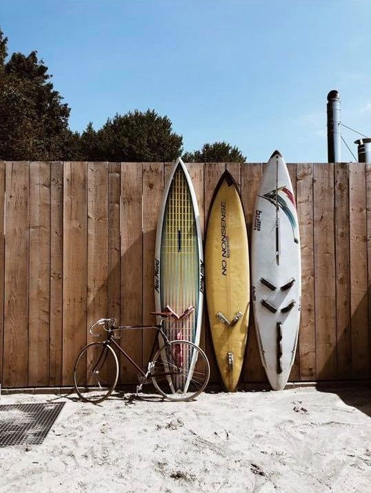 Surfplanken tegen houten schutting bij Strand Vier.
