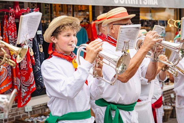 Een jongen en een man die op een trompet spelen