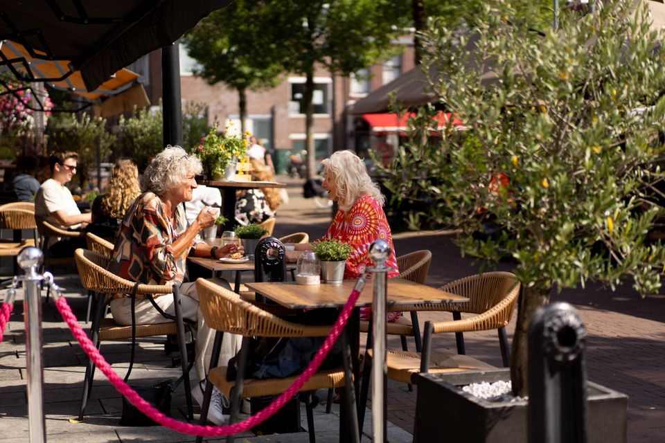 Verschillende mensen die op het terras zitten op de Koemarkt in Purmerend