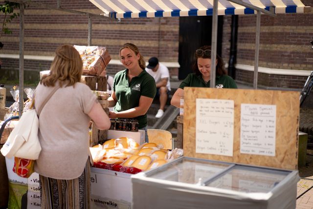 Iemand die kaas en andere streekproducten verkoopt op de Laag Hollandse Makersmarkt