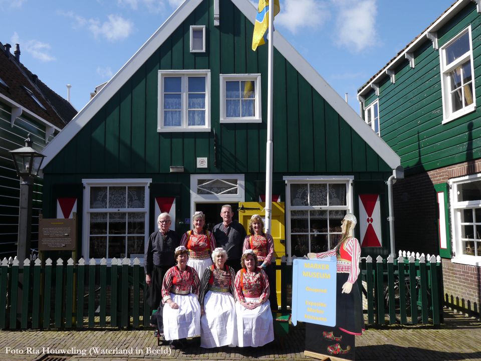 vier vrouwen en twee mannen poseren in Marker klederdracht voor het Marker museum