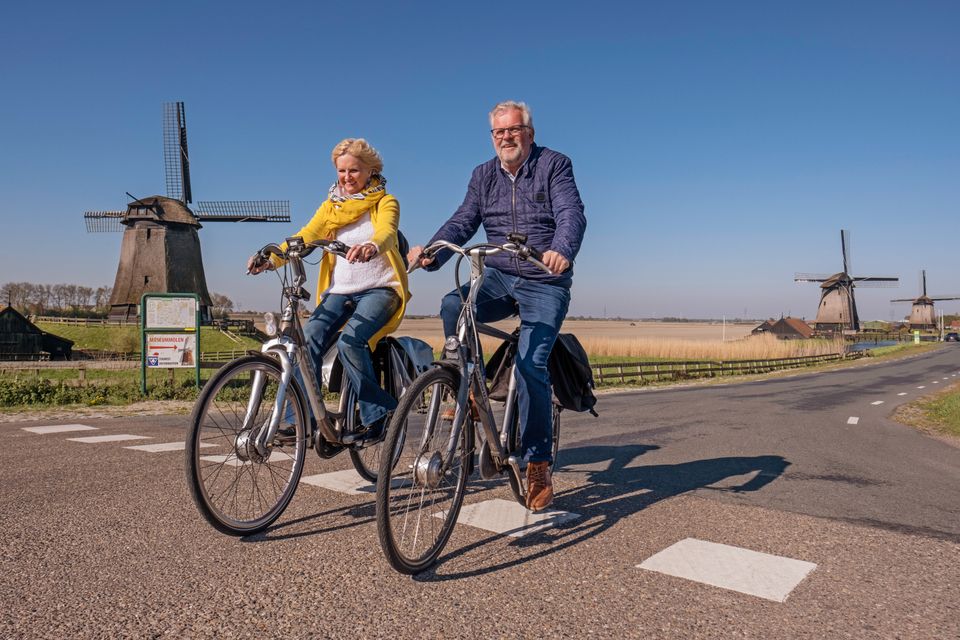 Man en vrouw die fietsen bij de Schermermolens
