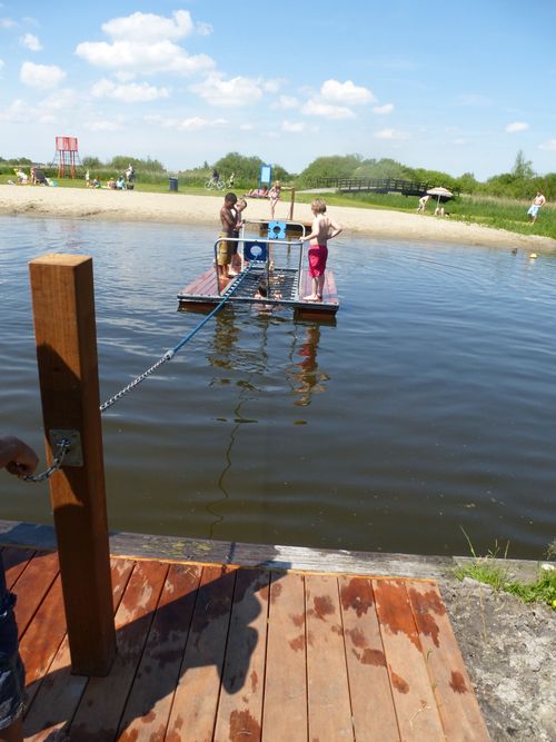 Kinderen trekken aan een touw om een vlot naar de overkant te halen