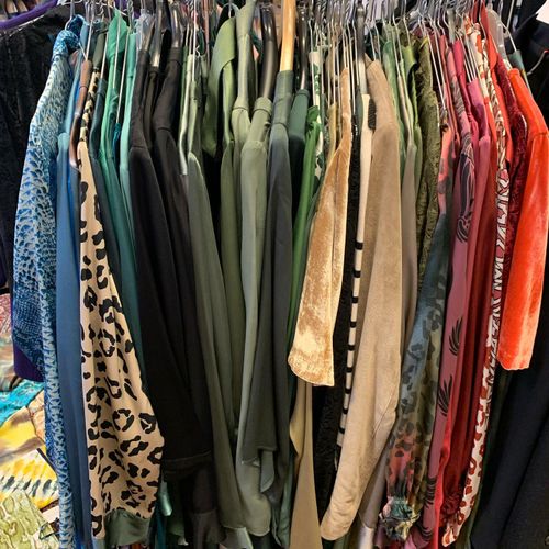 Kledingrek met kleurrijke kledingstukken bij Vintage Brands.