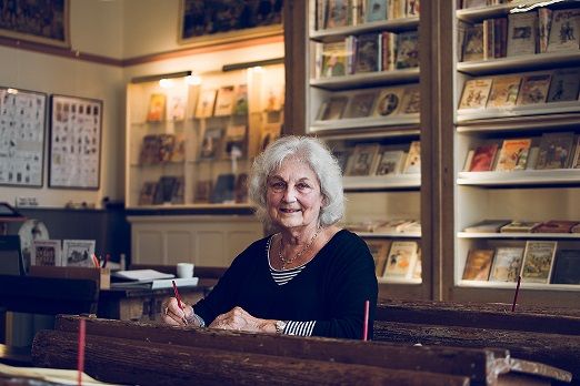 Mevrouw aan een schoolbankje in het Schooltje van Dik Trom.