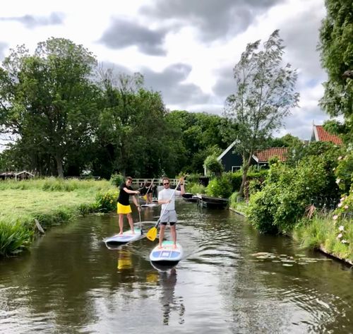 Drie mensen die aan het suppen zijn bij Zuiderwoude
