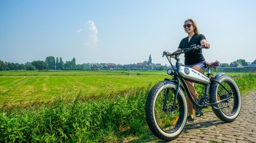 Een vrouw met een fatbike aan haar hand