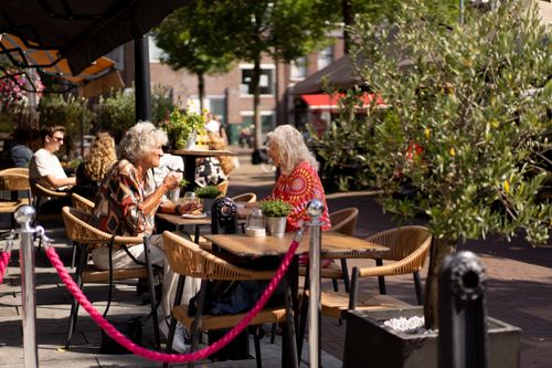 Verschillende mensen die op het terras zitten op de Koemarkt in Purmerend