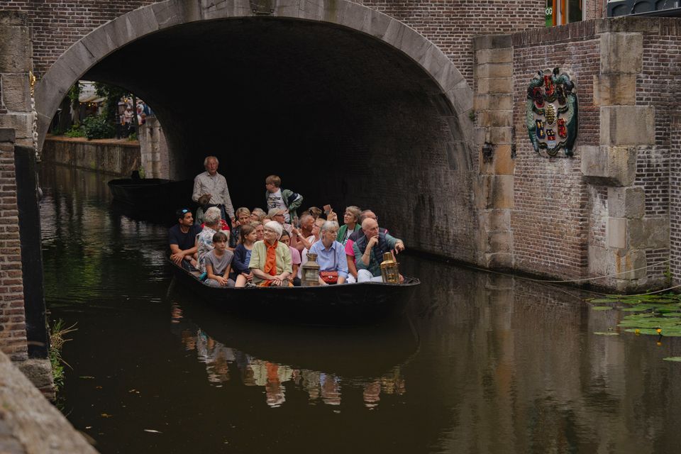 Een groep mensen die rondvaren op een Koeboot door Edam