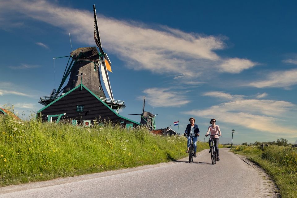 Twee vrouwen die fietsen langs een molen