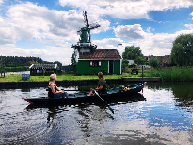 Twee mensen die aan het varen zijn door Oostzaan, langs de Biksteenmolen.
