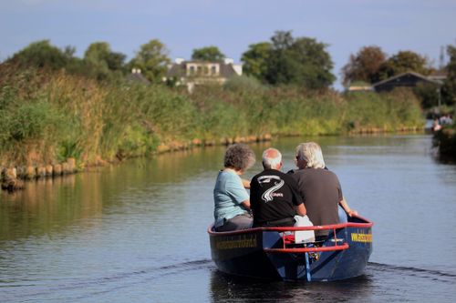 Mensen die varen in een bootje door het Ilperveld