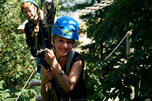 Een meisje met helm die aan het klimmen in in Klimpark Twiske.