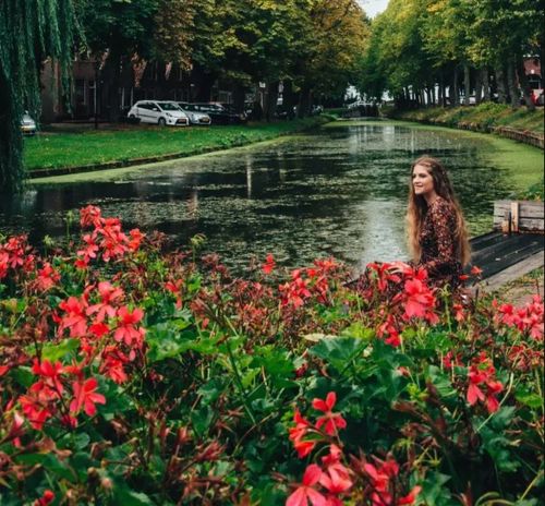 Een vrouw die aan de waterkant zit in Edam