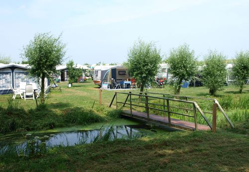 Mensen die aan het kamperen zijn met onder andere een caravan bij de Zeevangshoeve in Edam