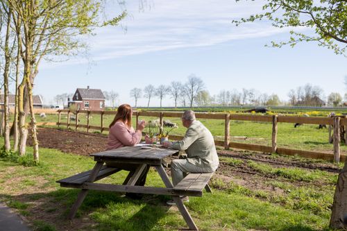 Twee mensen die op een picknick die wat drinken