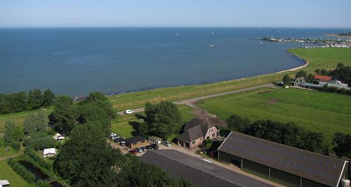 Een luchtfoto van Camping Zeevangshoeve in Edam die aan het water ligt