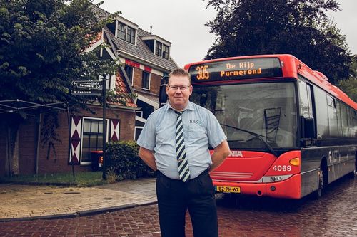 Buschauffeur voor zijn bus in Laag Holland.