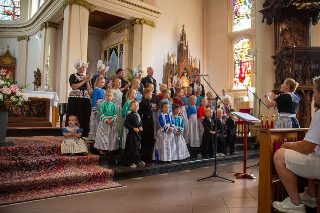 Kinderen in Volendammer kleding die aan het zingen zijn in de kerk