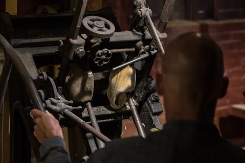 Iemand die een klomp aan het marken is bij klompenmakerij op Marken